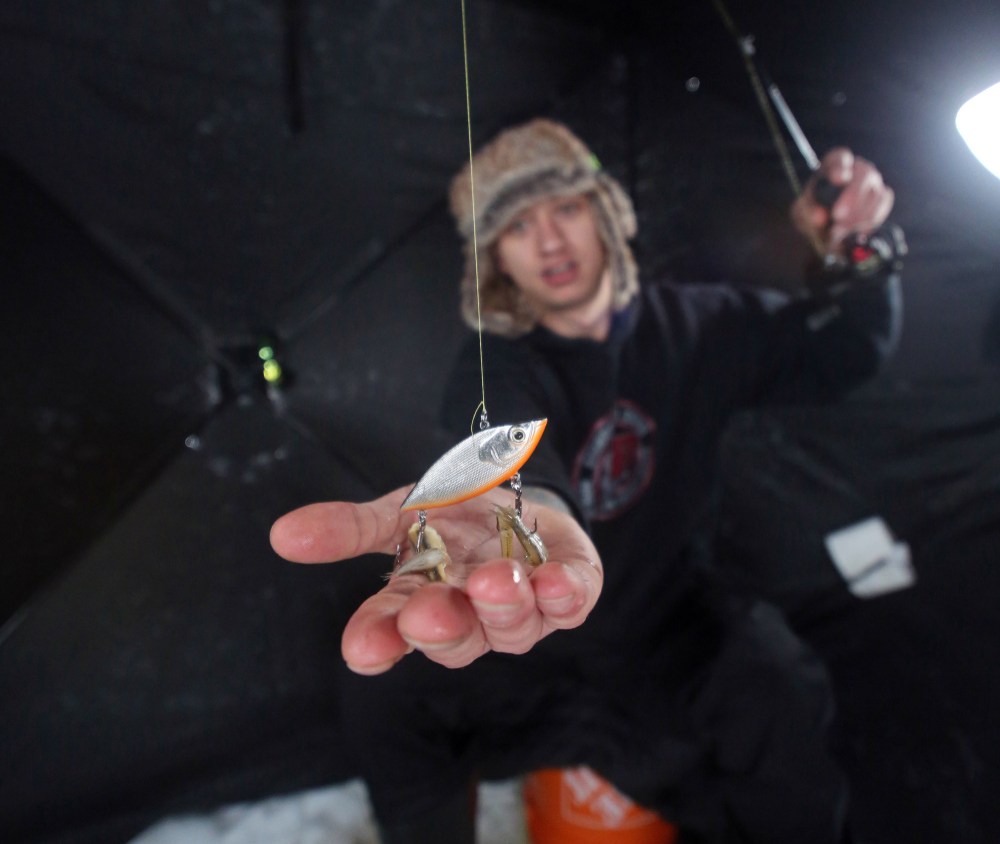Brandon's Tyler Baker displays his ice-fishing lure as he sits within his two-man tent on the Assiniboine River just down the trail from the Riverbank Discovery Centre. (Matt Goerzen/The Brandon Sun)