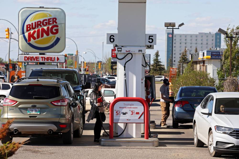 Motorists gas up at the Canadian Tire gas bar in Brandon on a windy Wednesday. Gas prices shot up to just under two dollars a litre at most Brandon stations. (Tim Smith/The Brandon Sun)