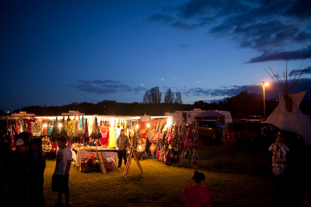 Tim Smith / Brandon Sun
A vendor sells clothes and other items at dusk at the 2016 Sioux Valley Dakota Nation Pow wow on Saturday evening.
