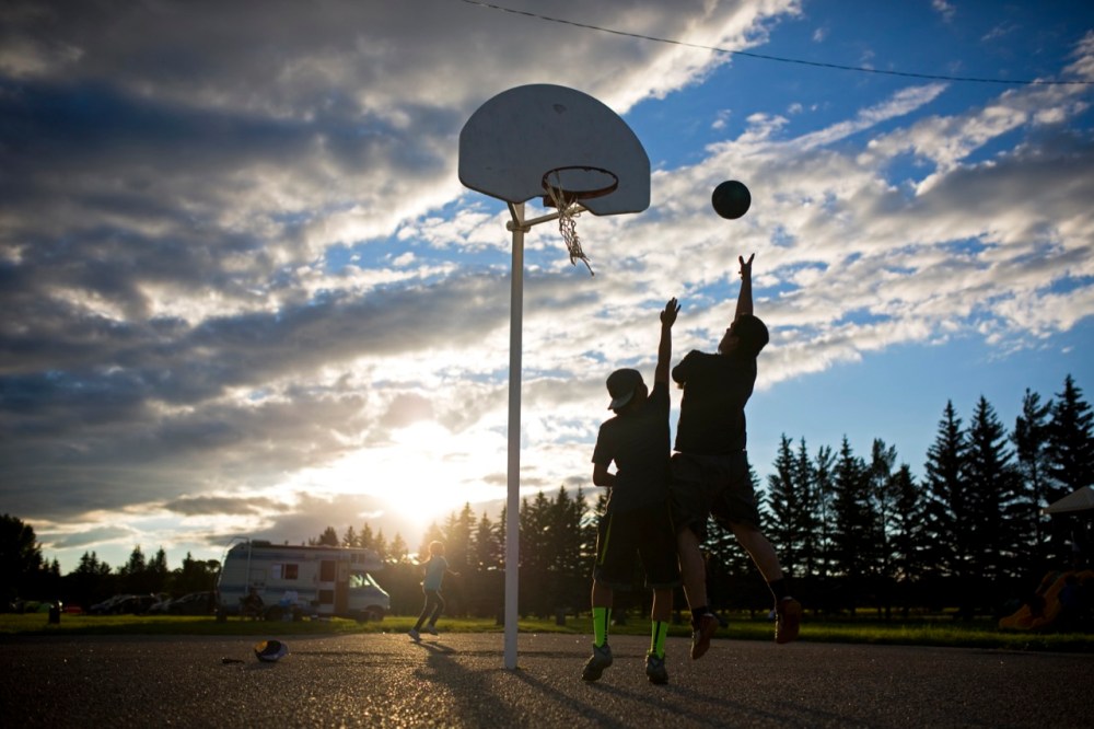 Tim Smith / Brandon Sun
Young men play basketball as clouds roll in at sunset at the 2016 Sioux Valley Dakota Nation Pow wow on Saturday evening.
