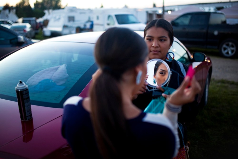 Tim Smith / Brandon Sun
Selena Hanska of Birdtail Sioux First Nation does her hair as friend Kaylee Huntinghawk of Rolling River First Nation holds a mirror at the 2016 Sioux Valley Dakota Nation Powwow on Saturday evening.