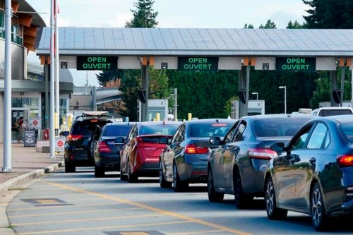 A line of vehicles wait to enter Canada at the Peace Arch border crossing Monday, Aug. 9, 2021, in Blaine, Wash.&nbsp;Border-city mayors, tourism industry leaders and an opposition MP say it’s time to bid a less-than-fond farewell to the ArriveCan app.&nbsp;(AP Photo/Elaine Thompson)