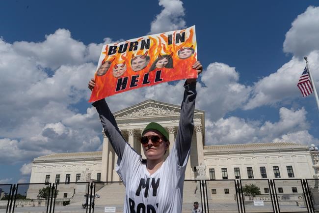 An abortion-rights protester displays a placard during a demonstration outside the Supreme Court in Washington, Saturday, June 25, 2022. The U.S. Supreme Court's decision to end constitutional protections for abortion has cleared the way for states to impose bans and restrictions on abortion — and will set off a series of legal battles. (AP Photo/Gemunu Amarasinghe)