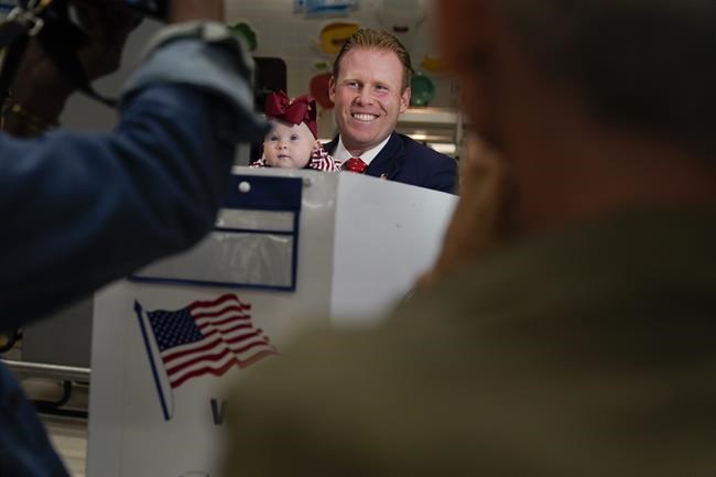 Republican gubernatorial candidate Andrew Giuliani talks to reporters while holding his daughter Grace as he votes in New York, Tuesday, June 28, 2022. New Yorkers are casting votes in a governor's race that for the first time in a decade does not include the name