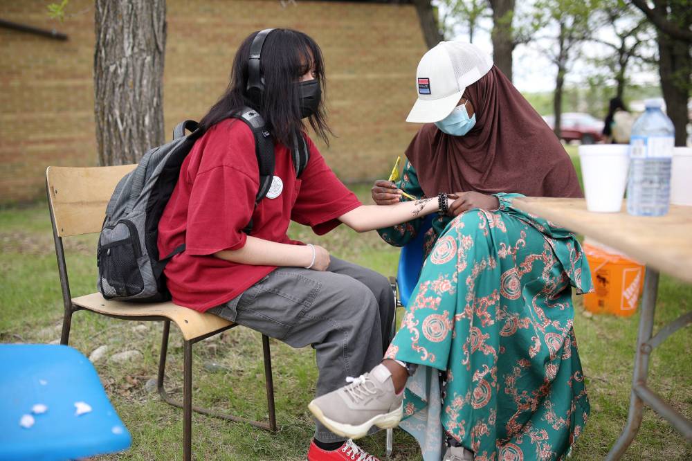 Tim Smith/The Brandon Sun
Winnipeg students Ayan Diriye (right) of Gordon Bell High School gives a henna tattoo to Jaspreet Manalili of Sisler High School while they take part in Sioux Valley Dakota Nation’s culture camp at the Grand Valley Campground Thursday.