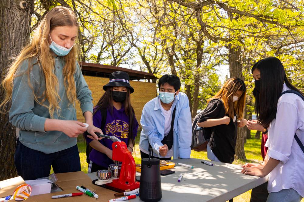 Chelsea Kemp/The Brandon Sun
Elena Eriyshin, 17, helps participants make buttons at the Sioux Valley Dakota Nation culture camp at Grand Valley Campground Thursday afternoon.