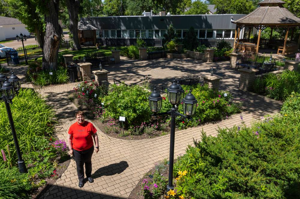 Chelsea Kemp/The Brandon Sun
Daly House Museum curator Eileen Trott stands in the property's Victorian garden courtyard on Saturday.