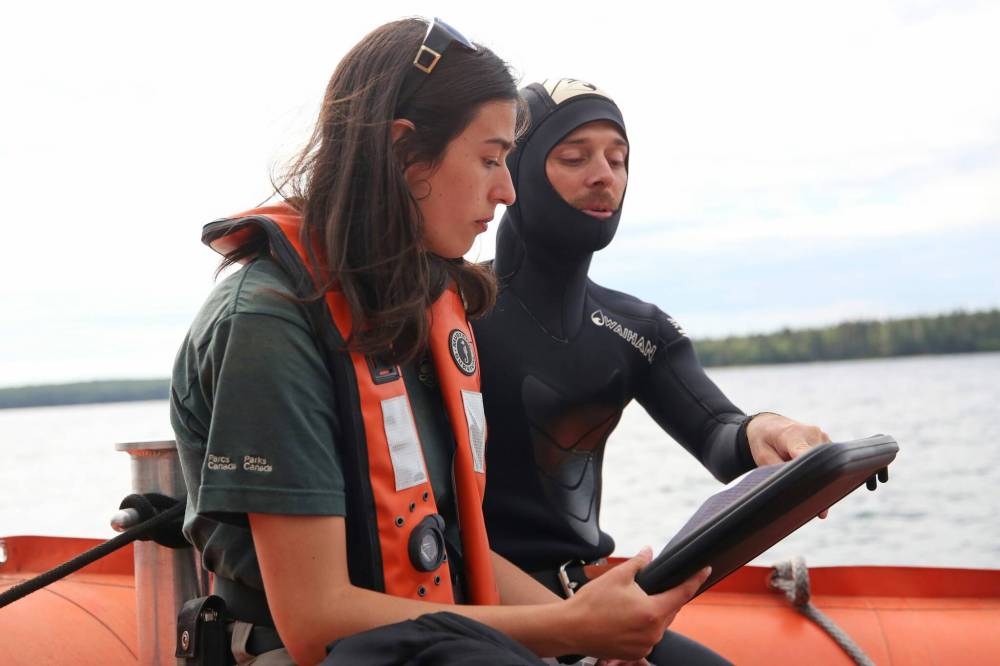 Matt Goerzen/The Brandon Sun
Resource conservation student Alex Prudhomme (right), a graduate student who is co-leader of the research team gathering information about the invasion of smallmouth bass at Clear Lake, goes over spearfishing and exploratory plans with Daniela Campama, a resource conservation student from Brandon University.
