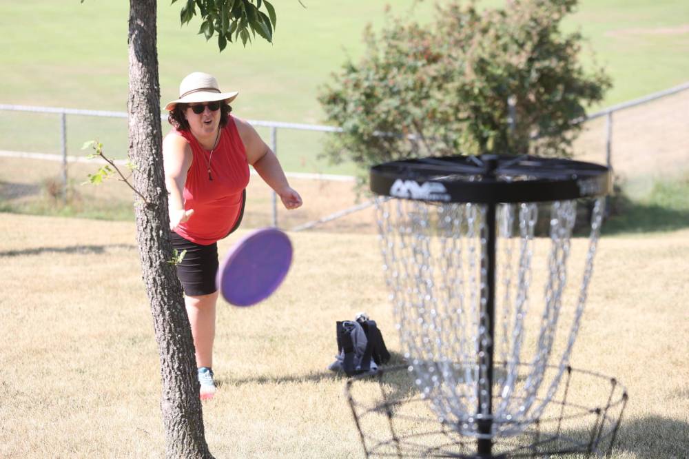 Julie Badiou grimaces after her frisbee bounces off a basket set up in Rideau Park on Sunday morning for a round of disc golf. (Kyle Darbyson/The Brandon Sun)