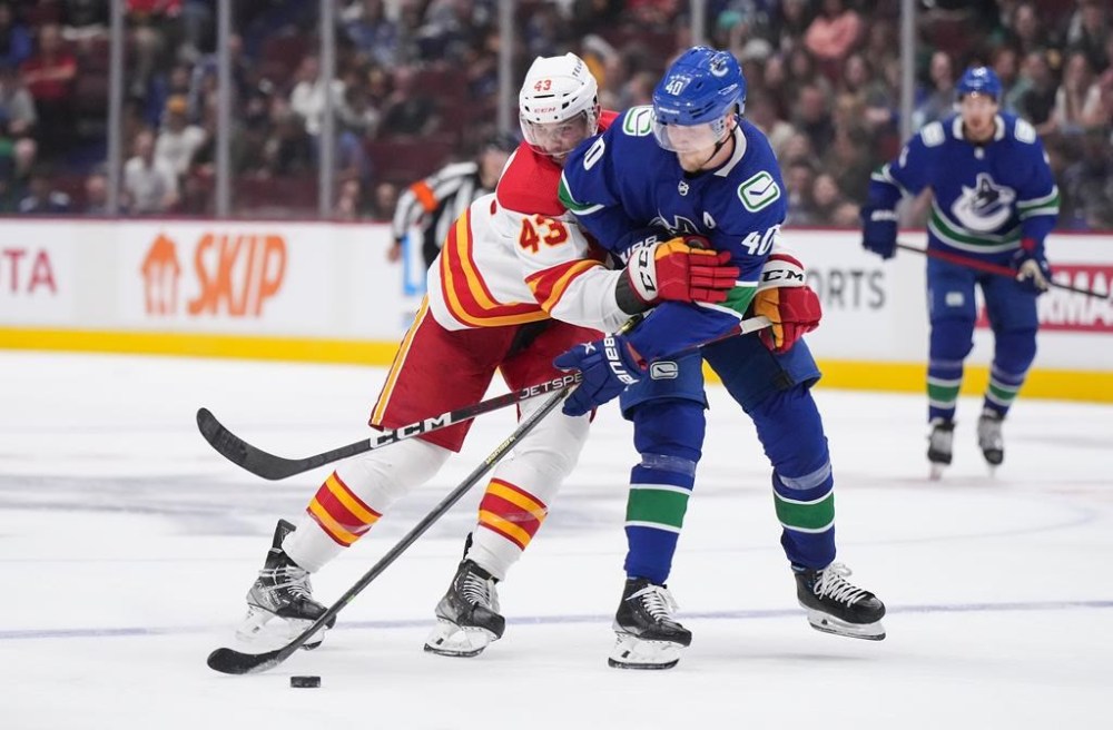 Calgary Flames' Adam Klapka, left, of the Czech Republic, ties up Vancouver Canucks' Elias Petterson, of Sweden, during the second period of a pre-season NHL hockey game in Vancouver, B.C., Sunday, Sept. 25, 2022. THE CANADIAN PRESS/Darryl Dyck