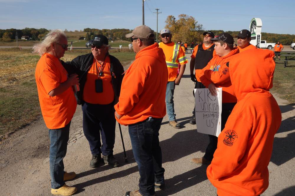 Mark Kovatch, owner of Turtle Crossing Campground, speaks with Gerald Bell, elder advisor for the Residential School Project, and Sioux Valley Dakota Nation Coun. Jonathan Bell during a protest organized by Sioux Valley at the entrance to the campground on Friday. (Tim Smith/The Brandon Sun)