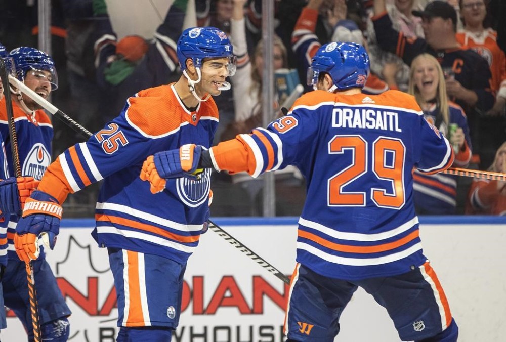 Edmonton Oilers' Darnell Nurse (25) and Leon Draisaitl (29) celebrate a goal against the Vancouver Canucks during second period NHL action in Edmonton on Wednesday, October 12, 2022. Nurse has been fined for interference during Edmonton's 5-3 win over the Vancouver Canucks on Wednesday. THE CANADIAN PRESS/Jason Franson