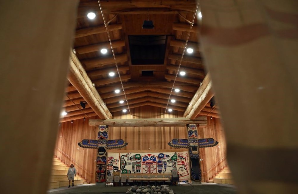 Maxwell Johnson, left, an Indigenous man from the Heiltsuk Nation, walks through the ceremonial area of the Big House in Bella Bella, B.C., Sunday, Oct. 23, 2022, in preparation for the Vancouver Police department’s formal apology and feast. Maxwell was wrongly handcuffed on the street outside a bank in Vancouver in December 2019 while trying to open a bank account for his then 12-year-old granddaughter Tori-Anne. THE CANADIAN PRESS/Chad Hipolito
