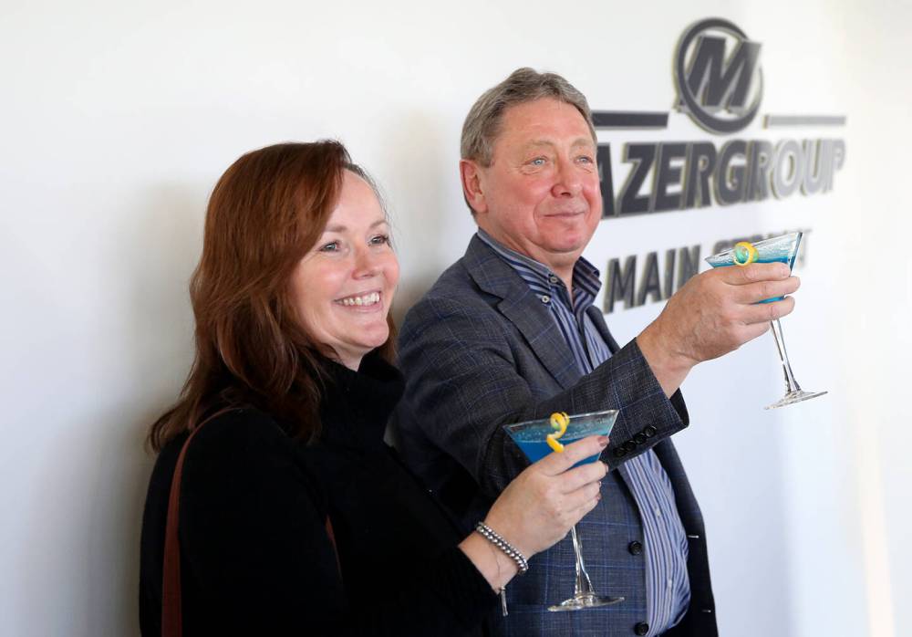 Mazergroup president and CEO Bob Mazer (right), accompanied by vice-president, people and culture Karen MacDonald, makes a toast in honour of Assiniboine Community College naming a portion of the Len Evans Centre for Trades and Technology after his company. The blue and yellow martinis were made in honour of Mazergroup, marking the fact that it is the largest New Holland dealership group in Canada. Blue and yellow are New Holland's colours. (Ian Hitchen/The Brandon Sun)