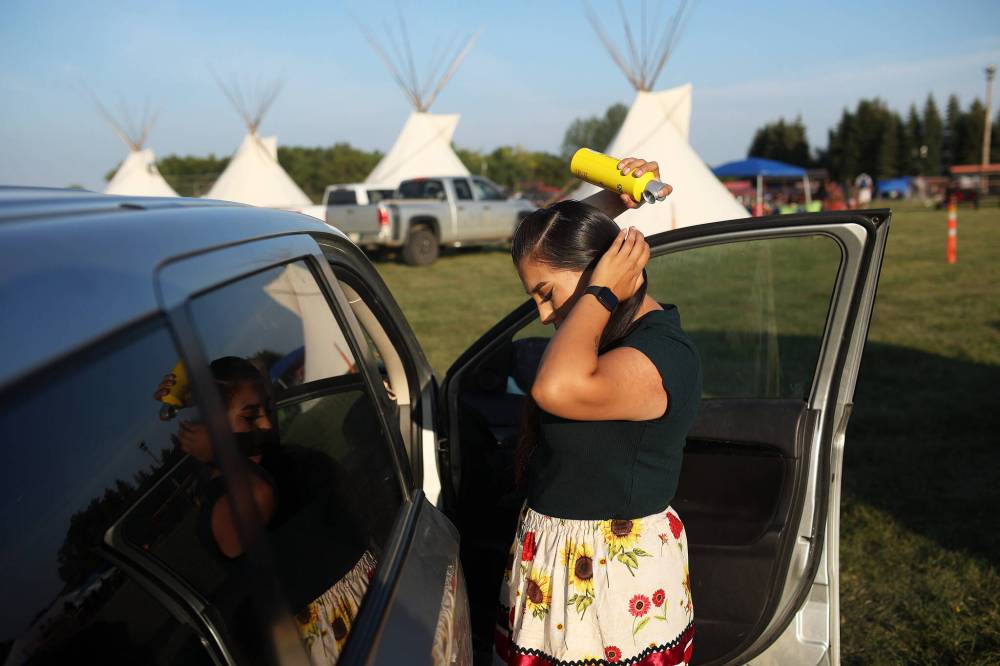 Selena Hanska of Birdtail First Nation does her hair while getting ready for the Sioux Valley Dakota Nation Powwow in August.