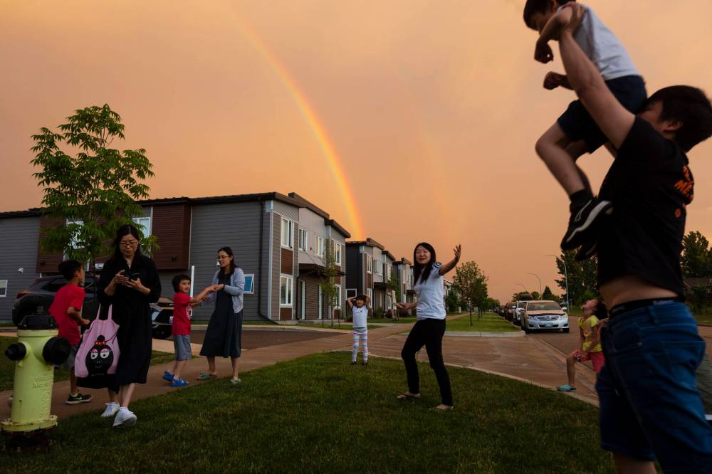 Residents of apartments along Tracey Street in Brandon’s south end congregate to watch and take photos of a double rainbow arching across the sky after an evening storm passed over Brandon in late June.