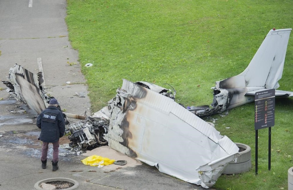 A member of the Transportation Safety Board of Canada inspects the wreckage of a plane at a crash site in Montreal, Sunday, Oct. 3, 2021. The small plane crashed on Île Ste-Hélène, near Montreal’s Old Port on Saturday. THE CANADIAN PRESS/Graham Hughes