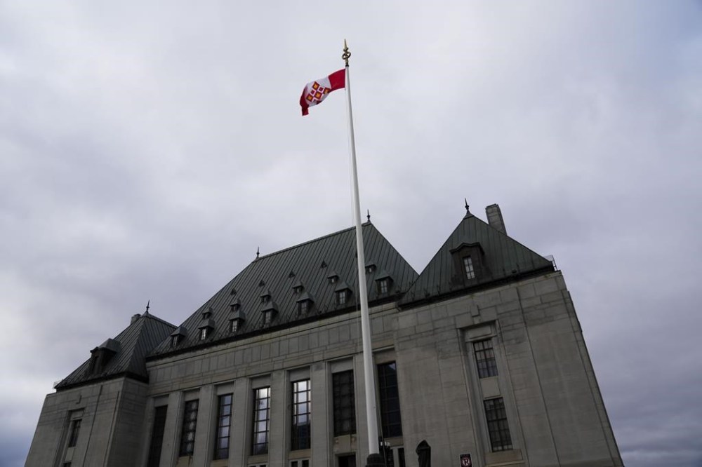 The flag of the Supreme Court of Canada flies on the east flag pole on Monday, Nov. 28, 2022. The Supreme Court of Canada plans to rule today on the constitutionality of mandatory minimum sentences in cases involving armed robbery and recklessly firing a gun. THE CANADIAN PRESS/Sean Kilpatrick