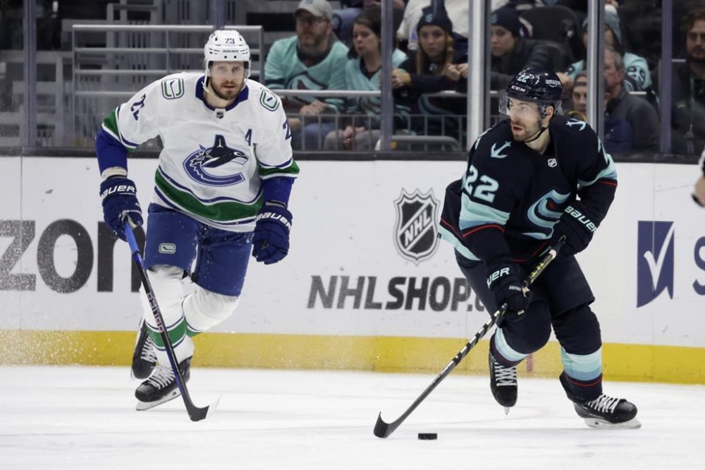 Seattle Kraken right wing Oliver Bjorkstrand (22) skates with the puck with Vancouver Canucks defenceman Oliver Ekman-Larsson trailing during the second period of an NHL hockey game Wednesday, Jan. 25, 2023, in Seattle.THE CANADIAN PRESS/AP/John Froschauer