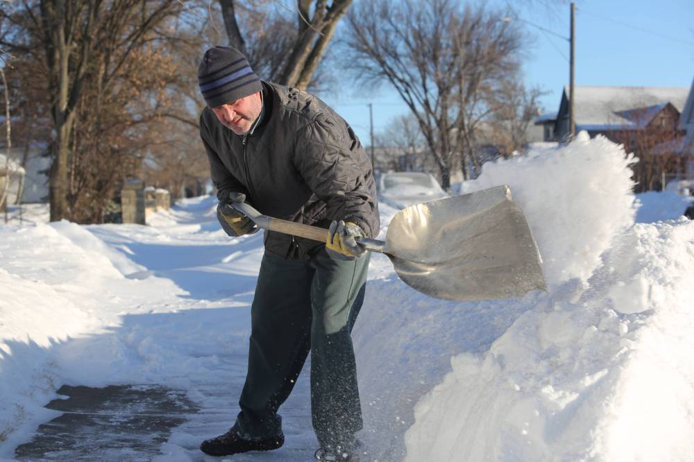 Brandon resident Murray Starkell clears a sidewalk outside his home on Sunday morning after a major blizzard blanketed the city in snow throughout Saturday. (Kyle Darbyson/The Brandon Sun)