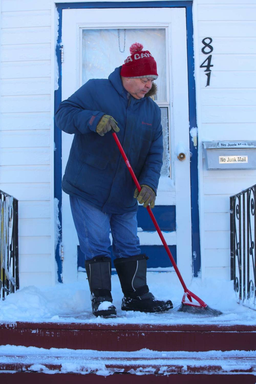 Brandon resident Kerry Fast sweeps some snow off his front steps Sunday morning in the wake of a major blizzard that dumped a significant amount of snow on the city on Saturday. (Kyle Darbyson/The Brandon Sun)