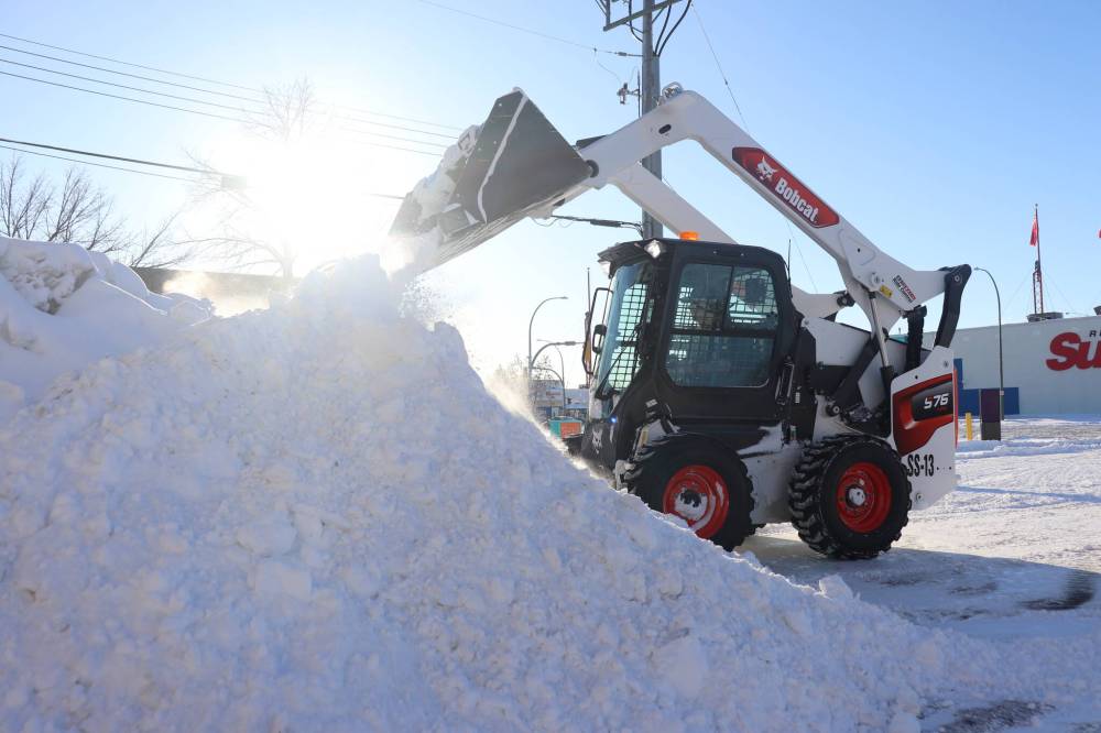 A member of Livingstone Landscaping clears the Popeyes Louisiana Kitchen parking lot in Brandon on Sunday morning following a significant snowfall over the weekend. (Kyle Darbyson/The Brandon Sun)