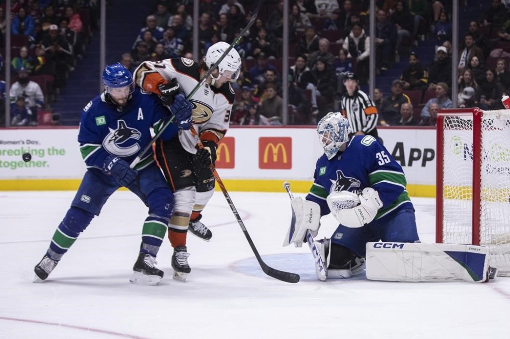 Vancouver Canucks goaltender Thatcher Demko (35) makes a save against Anaheim Ducks' Mason McTavish (37) as Canucks' J.T. Miller (9) during the third period of an NHL hockey game in Vancouver on Wednesday, March 8, 2023. THE CANADIAN PRESS/Ben Nelms
