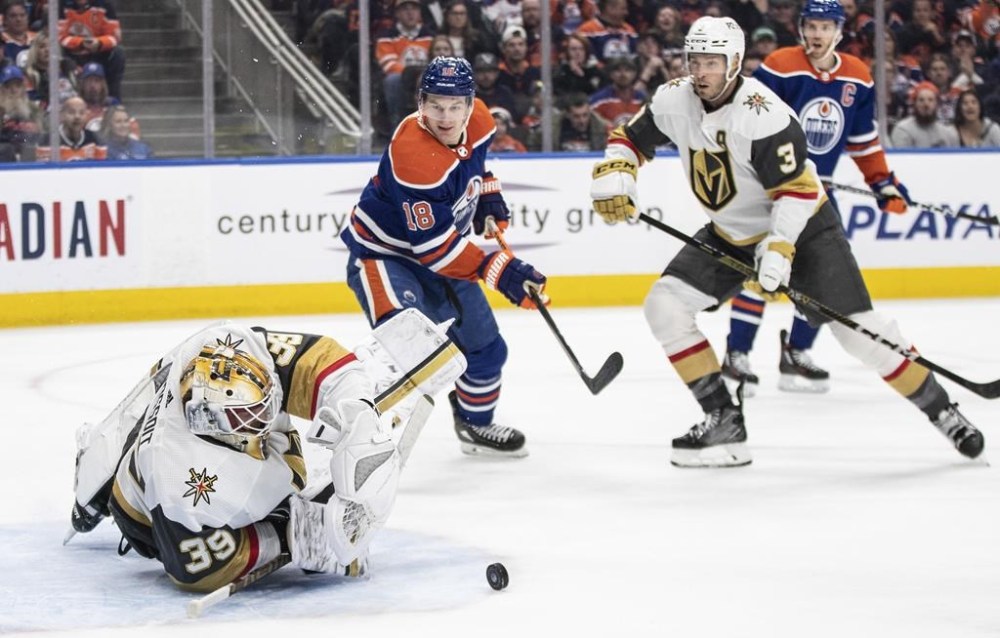 Vegas Golden Knights goalie Laurent Brossoit (39) makes the save as Edmonton Oilers' Zach Hyman (18) and Brayden McNabb (3) look for the rebound during second period NHL action in Edmonton on Saturday March 25, 2023.THE CANADIAN PRESS/Jason Franson