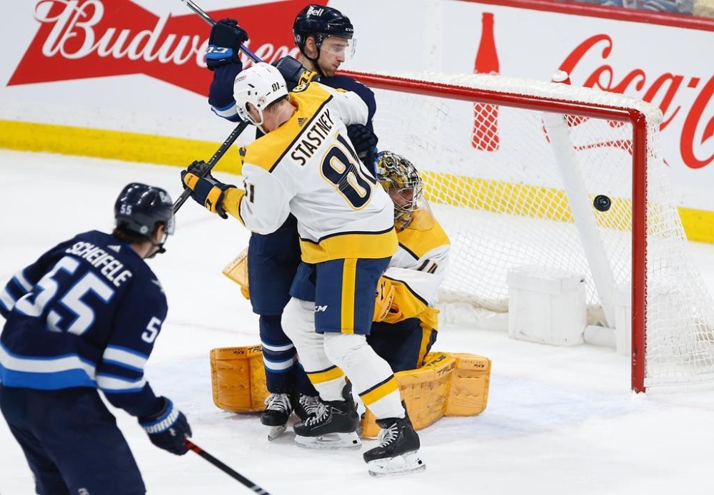 Winnipeg Jets' Mark ScheifeleÕs (55) shot gets past Nashville Predators goaltender Juuse Saros (74) as Spencer Stastney (81) defends against Neal Pionk (4) during second period NHL action in Winnipeg, Saturday, April 8, 2023. THE CANADIAN PRESS/John Woods