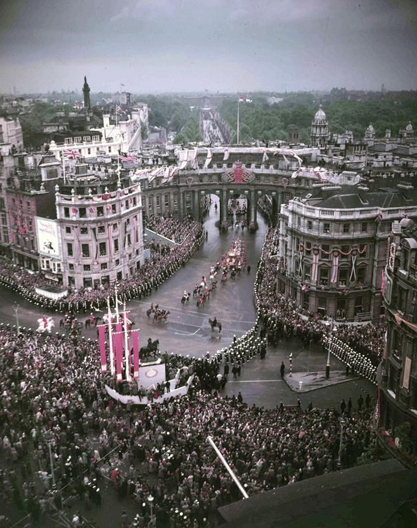 FILE - The Golden Coach, with the newly crowned Queen Elizabeth II inside, passes under Admiralty Arch, London, June 2, 1953, as it returns to Buckingham Palace following the Coronation of the Queen in Westminster Abbey. In 1953, London was still recovering from World War II. The city was pockmarked with bomb damage, food supplies were tight and life was dull for children who had never eaten anything so exotic as a banana. But the coronation of Queen Elizabeth II helped lift the gloom. (AP Photo/Dennis-Lee Royle, File)