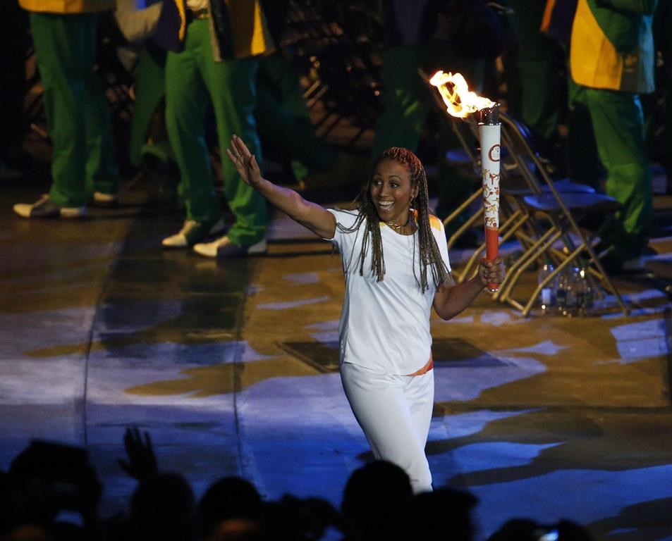 Olympian Charmaine Crooks carries the Pan Am flame during the opening ceremony of the 2015 Pan Am Games in Toronto, Friday, July 10, 2015. Crooks has been elected president of Canada Soccer. THE CANADIAN PRESS/AP-Julio Cortez
