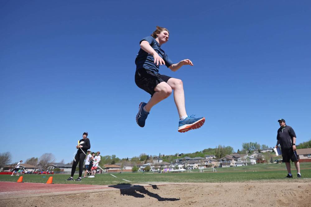 Thomas Seitz, a Grade 8 student from École Harrison, sails through the air while competing in the triple jump event at the school's track and field day at the UCT Stadium on Friday. (Tim Smith/The Brandon Sun)