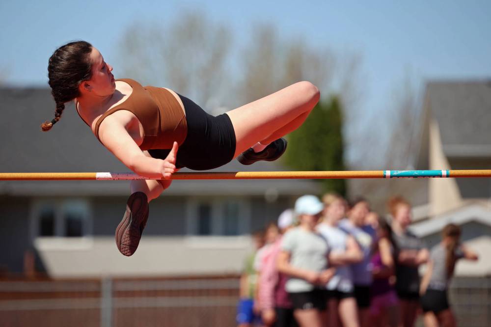 Mila Yuel, a Grade 8 student from École Harrison, leaps over the bar while competing in the high-jump event at the school's track and field day at the UCT Stadium on Friday. (Tim Smith/The Brandon Sun)
