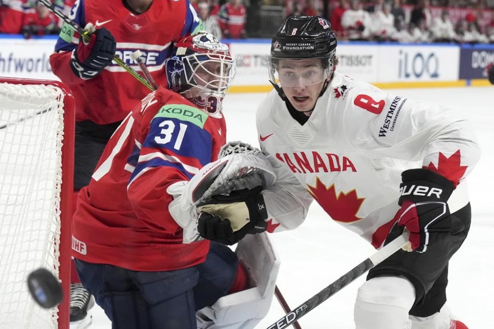 Cody Glass of Canada, right, fights for a puck with goalie Jonas Arntzen of Norway during the group B match between Canada and Norway at the ice hockey world championship in Riga, Latvia, Monday, May 22, 2023. THE CANADIAN PRESS/AP-Roman Koksarov