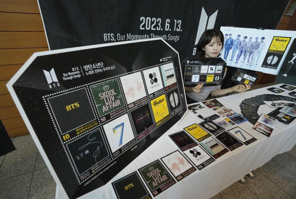 A model shows sheets of postage stamps marking the 10th debut anniversary of K-pop band BTS at a post office in Seoul, South Korea, Monday, June 12, 2023. Post offices start selling the stamps Tuesday. (AP Photo/Ahn Young-joon)