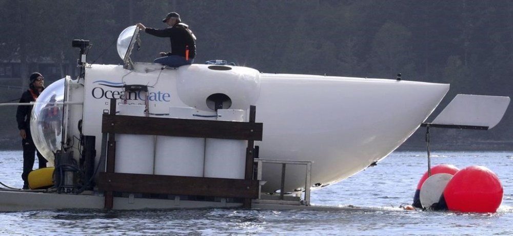FILE - OceanGate CEO Stockton Rush emerges from the hatch atop the OceanGate submarine Cyclops 1 in the San Juan Islands, Wash., on Sept. 12, 2018. Rescuers are racing against time to find the missing submersible carrying five people, who were reported overdue Sunday night, June 18, 2023. (Alan Berner/The Seattle Times via AP, File)