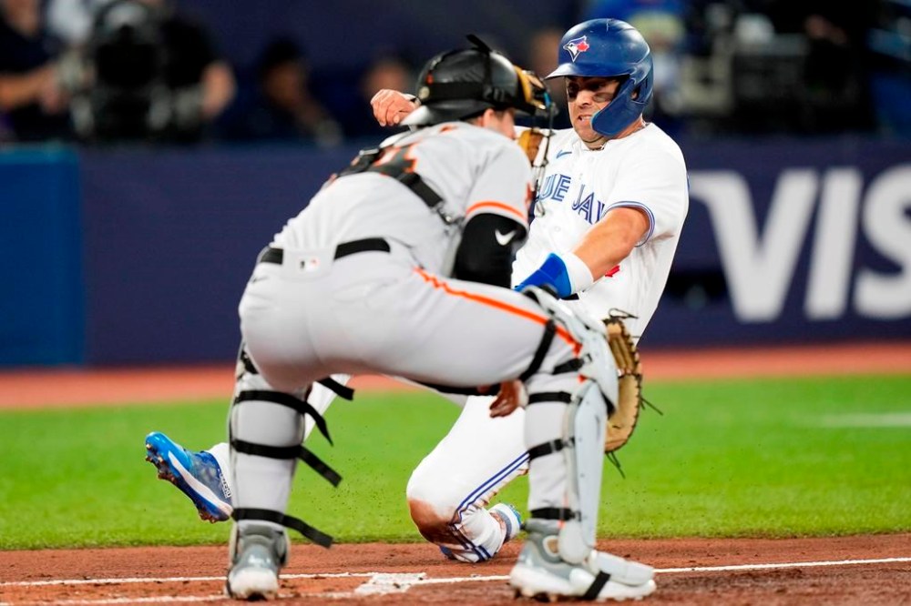 Toronto Blue Jays' Whit Merrifield (15) slides safely into home plate ahead of the tag from San Francisco Giants catcher Patrick Bailey (14) on an RBI single by Blue Jays' Danny Jansen (not shown) during first inning MLB Interleague baseball action in Toronto, on Wednesday, June 28, 2023.THE CANADIAN PRESS/Frank Gunn