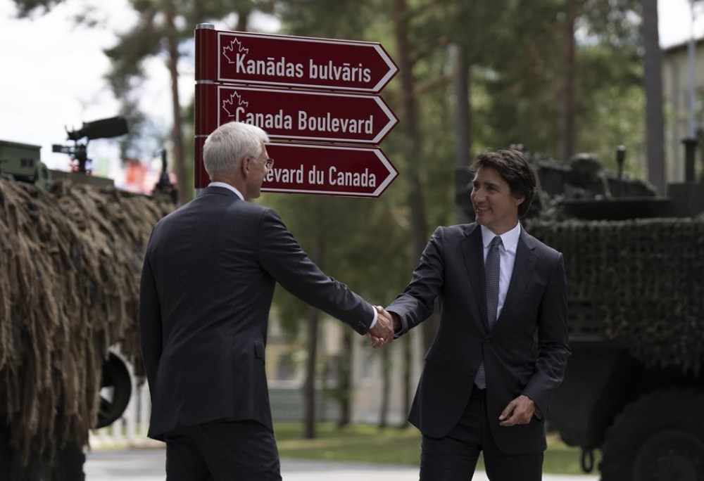 Prime Minister Justin Trudeau and Latvian Prime Minister Krisjanis Karins shake hands after unveiling a street sign honouring Canada at the Adazi Military base, Monday, July 10, 2023 in Adazi, Latvia. THE CANADIAN PRESS/Adrian Wyld