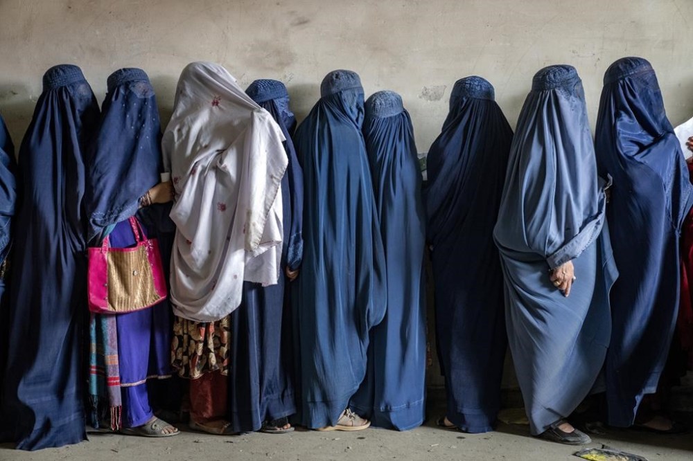 FILE - Afghan women wait to receive food rations distributed by a humanitarian aid group, in Kabul, Afghanistan, Tuesday, May 23, 2023. In a report issued on Monday, July 17, 2023, the U.N. says Taliban authorities have further increased restrictions on the rights of women and girls in Afghanistan in recent months. (AP Photo/Ebrahim Noroozi, File)