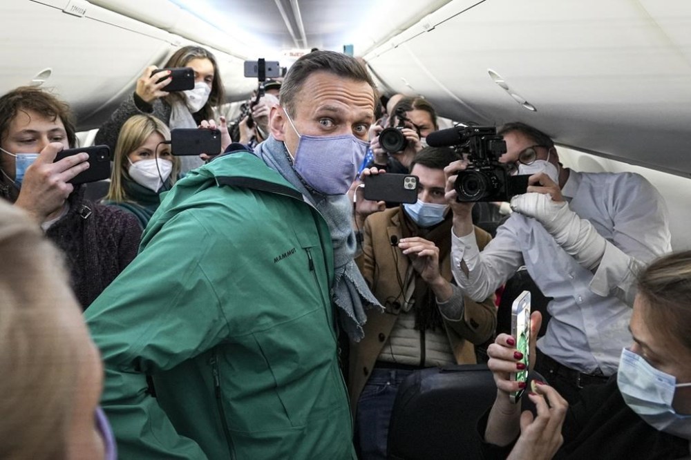 FILE - Alexei Navalny is surrounded by journalists on a plane before a flight to Moscow in the Berlin Brandenburg Airport, Jan. 17, 2021. The prosecution has asked the court to sentence imprisoned opposition leader Alexei Navalny to 20 years in prison on extremism charges, his ally Ivan Zhdanov said Thursday July 20, 2023. According to Zhdanov, the trial against Navalny, which went on behind closed doors in the prison where the politician is serving another lengthy sentence, is scheduled to conclude with a verdict on Aug. 4. (AP Photo/Mstyslav Chernov, File)