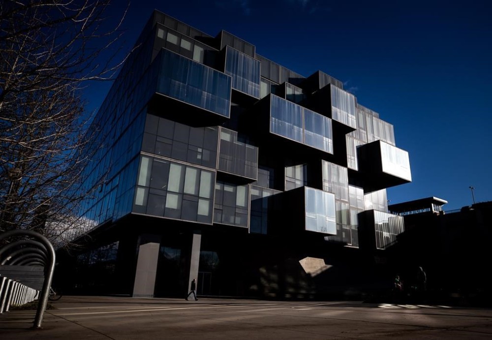 A person walks past the Faculty of Pharmaceutical Sciences building at the University of British Columbia as sunlight reflects off the windows in Vancouver on Wednesday, December 8, 2021. The University of British Columbia has named Benoit-Antoine Bacon as its new president and vice-chancellor. THE CANADIAN PRESS/Darryl Dyck