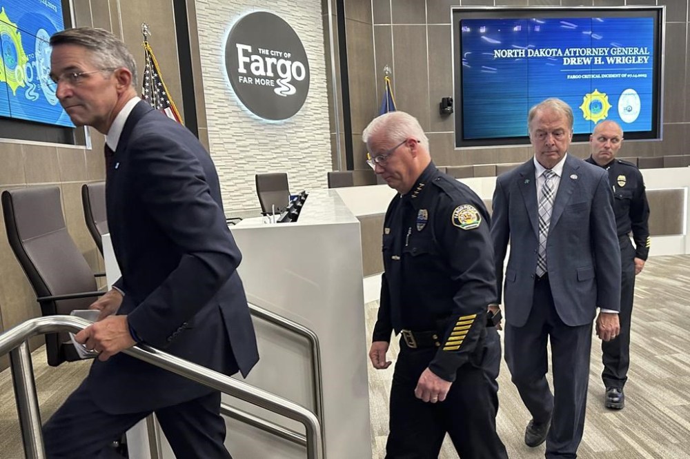 North Dakota Attorney General Drew Wrigley, Fargo Police Chief David Zibolski, Fargo Mayor Tim Mahoney and Assistant Chief Travis Stefonowicz exit the City Commission Chambers on Friday, July 21, 2023, after a news conference in Fargo, N.D. The man who shot three Fargo police officers and a civilian, killing one of the officers before an officer killed him, searched the internet for terms including “explosive ammo” and “kill fast,” as well as for what crowded area events might be happening in and around North Dakota's largest city, authorities said Friday. (AP Photo/Jack Dura)