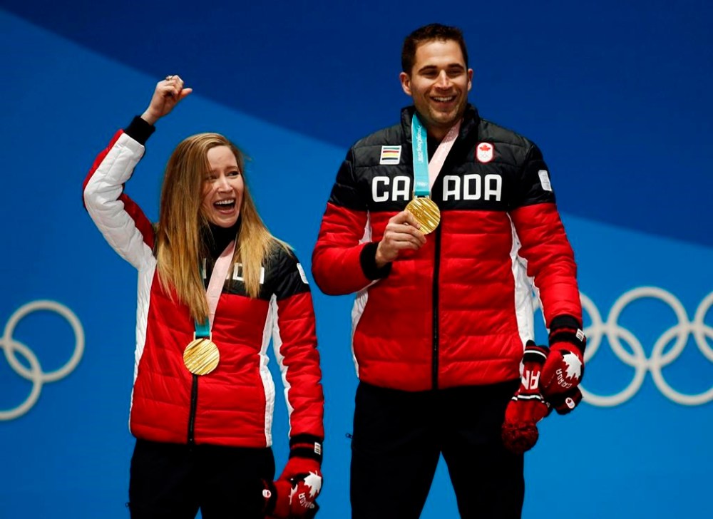 Curling mixed doubles gold medallists Kaitlyn Lawes, left, and John Morris, of Canada, celebrate during the medals ceremony at the 2018 Winter Olympics in Pyeongchang, South Korea, Wednesday, Feb. 14, 2018. Canadian curlers will be able to compete in both mixed doubles and four-player teams at the 2026 Winter Olympics. THE CANADIAN PRESS/AP-Patrick Semansky