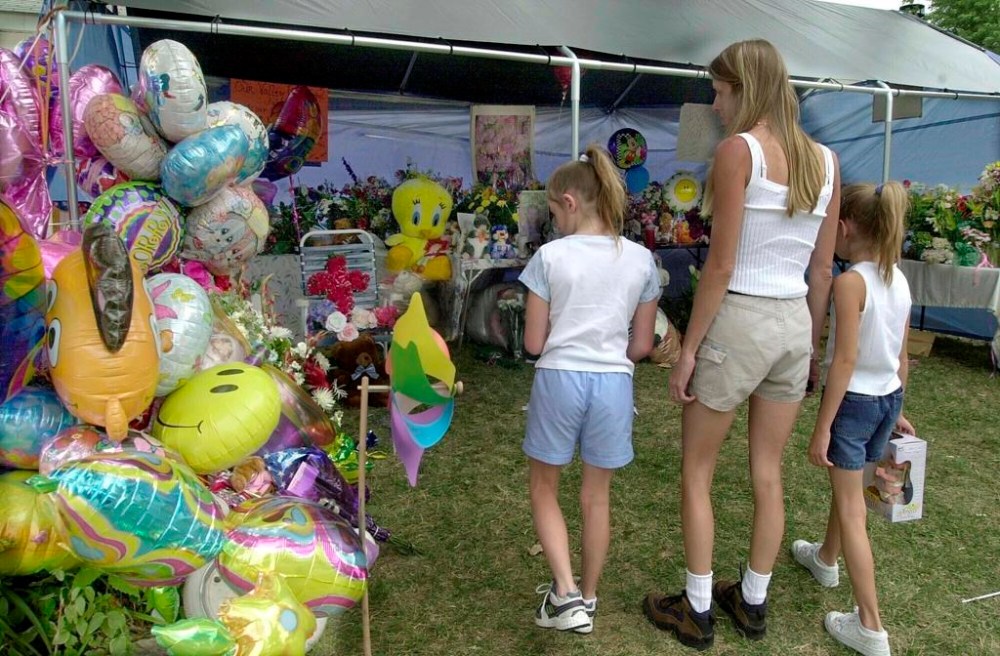 FILE - People look at the makeshift memorial in front of the home of Cassandra ''Casey'' Williamson, July 29, 2002, in Valley Park, Mo. Johnny Johnson who abducted and beat to death a 6-year-old girl was scheduled to be executed on Tuesday, Aug. 1, 2023, in Missouri, as his attorneys pressed claims that he is mentally incompetent. (AP Photo/Diane L. Wilson, File)