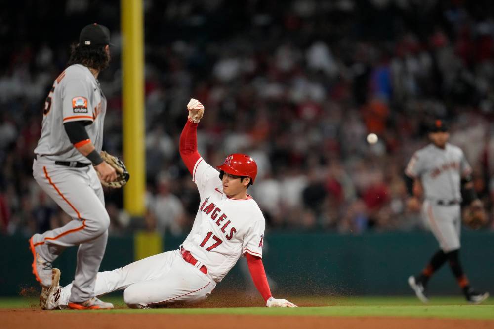 Los Angeles Angels’ Shohei Ohtani (17) slides in to second base as Brandon Drury flies out during the eighth inning of a baseball game against the San Francisco Giants in Anaheim, Calif., Wednesday, Aug. 9, 2023. (AP Photo/Ashley Landis)