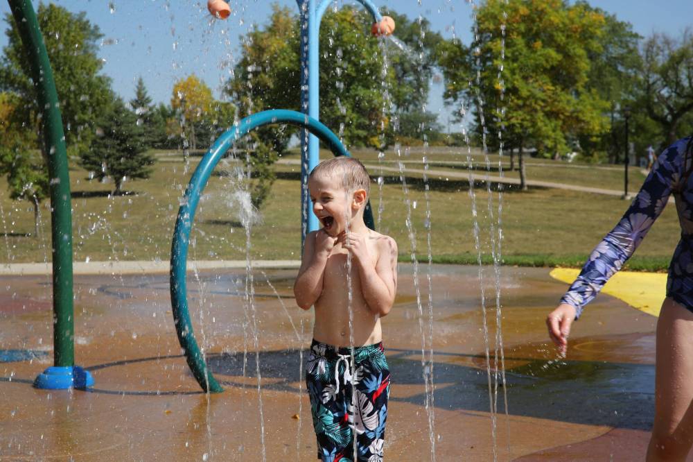 Siblings Thaddeus and Maisie (below) play with the stationary water spouts at Rideau Splash Park on Wednesday afternoon. The pair spent the day at the water park with their siblings and mom, who asked the Sun to use their first names only.