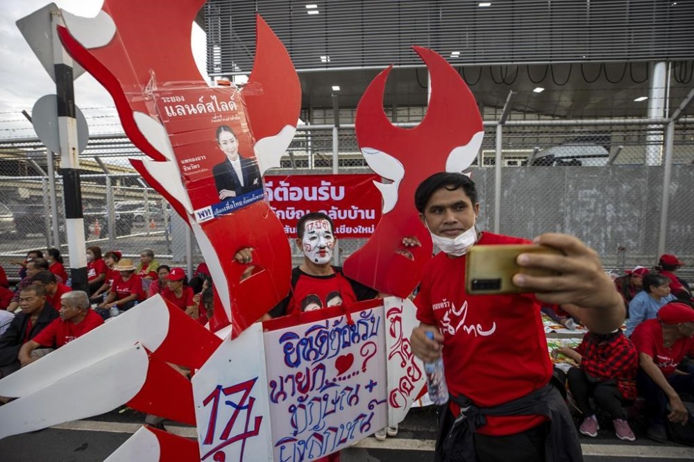 Supporters of Thai ex-Prime Minister Thaksin Shinawatra gather outside Don Mueang International Airport in Bangkok, Tuesday, Aug. 22, 2023. Divisive Shinawatra is expected to return to Thailand after years of self-imposed exile to face criminal charges on the same day that a party affiliated with him plans to start forming a new government. (AP Photo/Wason Wanichakorn)