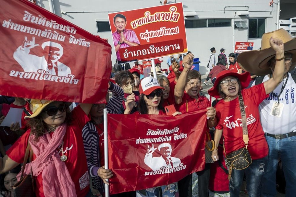 Supporters of Thailand's former Prime Minister Thaksin Shinawatra await his arrival outside Don Mueang International Airport in Bangkok, Tuesday, Aug. 22, 2023. Shinawatra is expected to return to Thailand after years of self-imposed exile to face criminal charges on the same day that a party affiliated with him plans to start forming a new government. (AP Photo/Wason Wanichakorn)