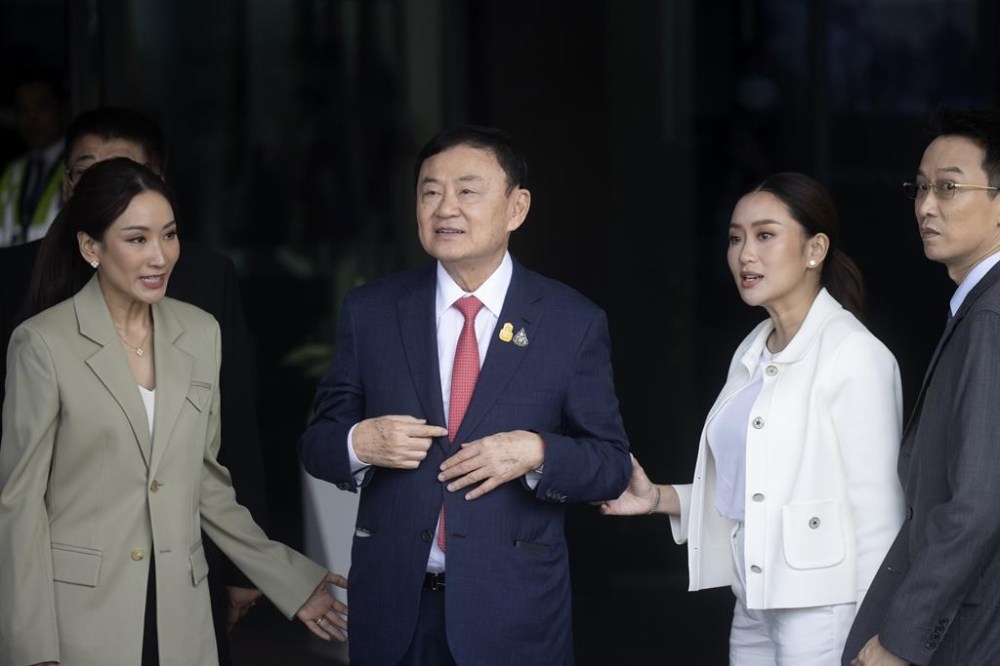 Thailand's former Prime Minister Thaksin Shinawatra, second left, walks with his son Panthongtae, his daughters Pinthongta and Paetongtarn, second right, as he arrives at Don Muang airport in Bangkok, Thailand, Tuesday, Aug. 22, 2023. (AP Photo/Wason Wanichakorn)