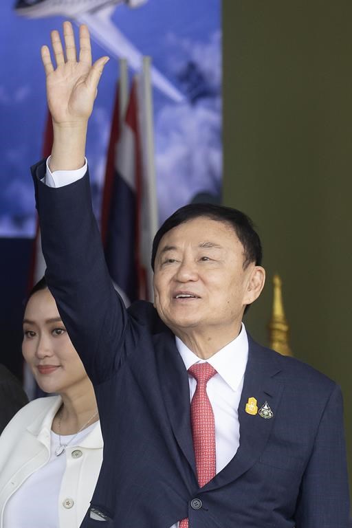 Thailand's former Prime Minister Thaksin Shinawatra waves to his supporters as he arrives at Don Muang airport in Bangkok, Thailand, Tuesday, Aug. 22, 2023. (AP Photo/Wason Wanichakorn)